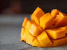 a sliced mango cubes on gray surface