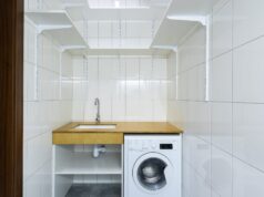 laundry area with white tiled walls