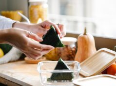 unrecognizable woman with onigiri at kitchen counter