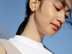 charming asian woman under blue sky in sunshine